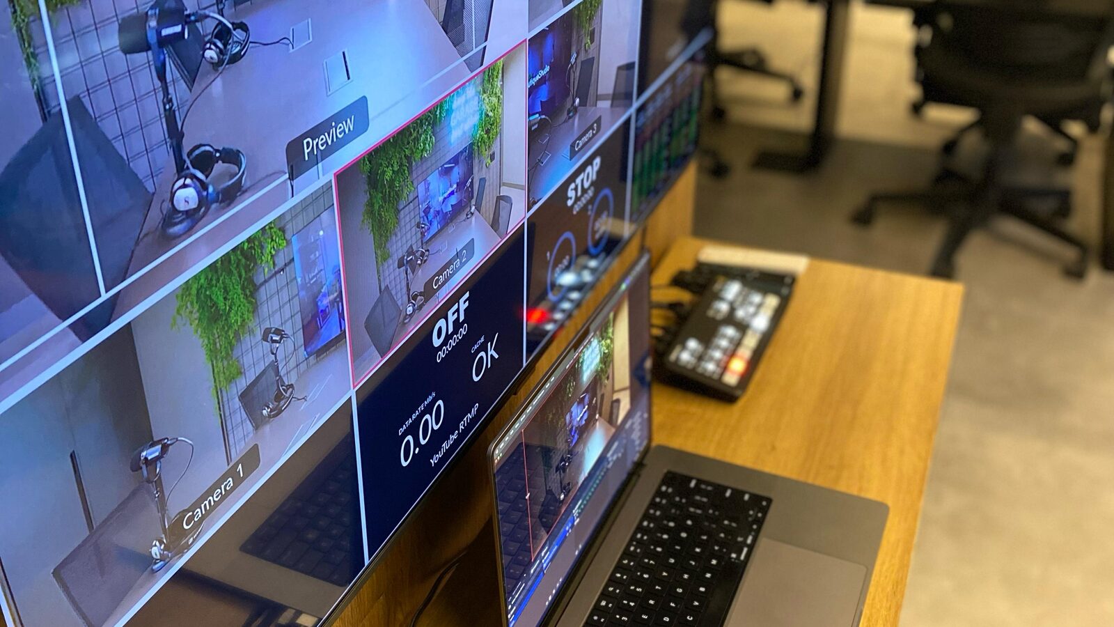 Bancada de controle com monitores multicâmera, laptop e planta